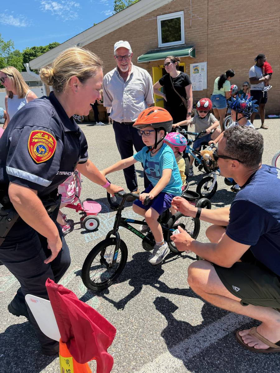 A child on a bicycle getting help from a police officer at Bike & Ice Cream Day