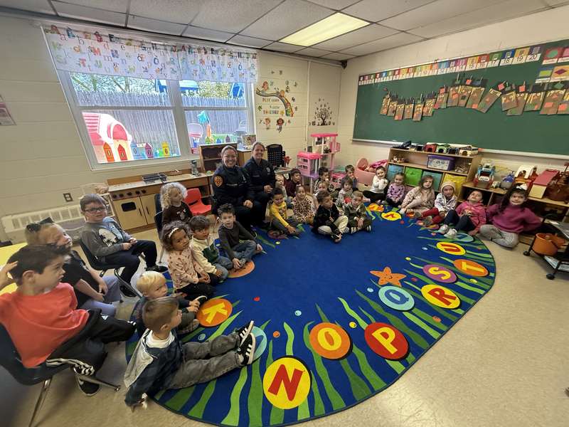 Teachers and a classroom of children gathered on the rug during circle time