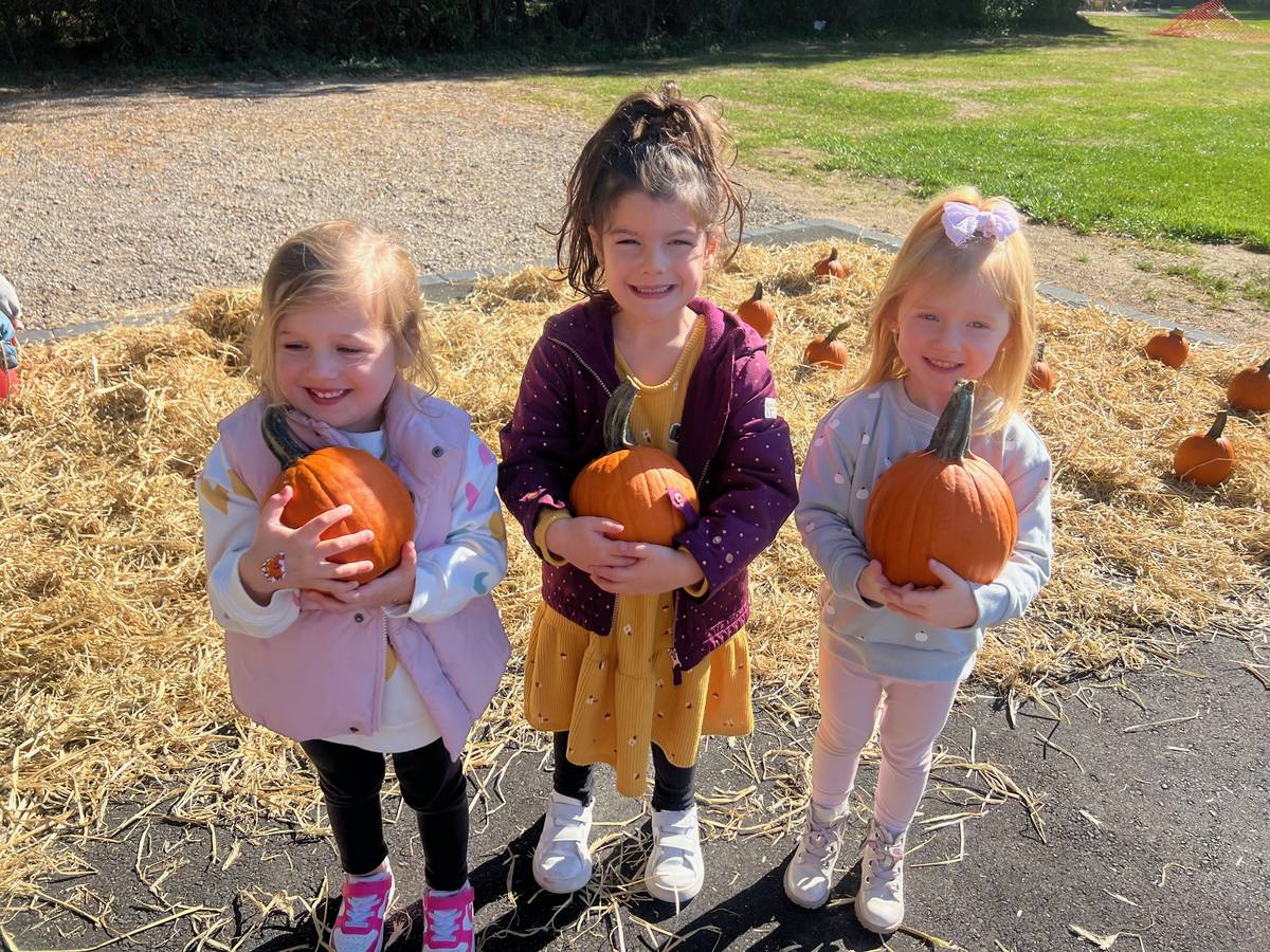 Humpty Dumpty students holding pumpkins at the annual Fall Festival pumpkin patch