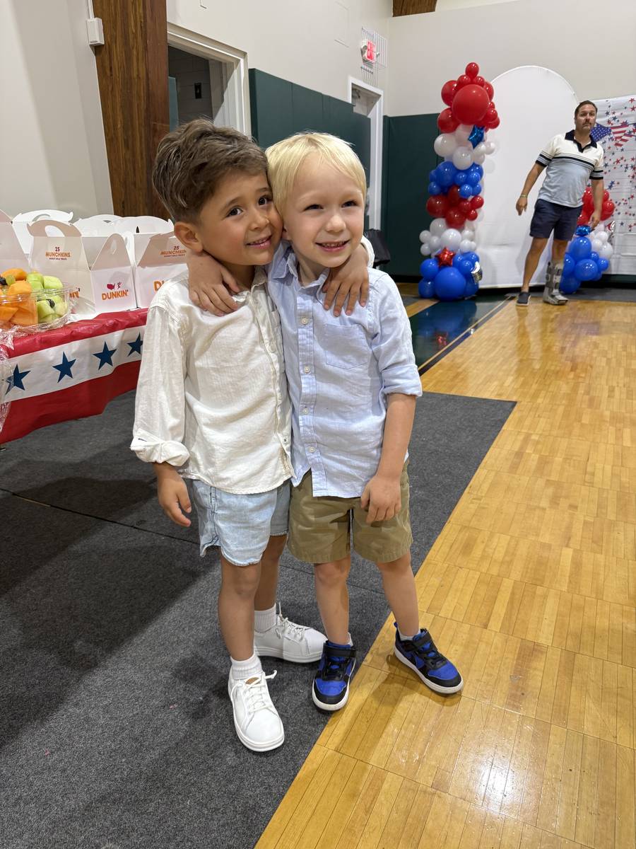 Two Humpty Dumpty graduates hugging at their end-of-year celebration